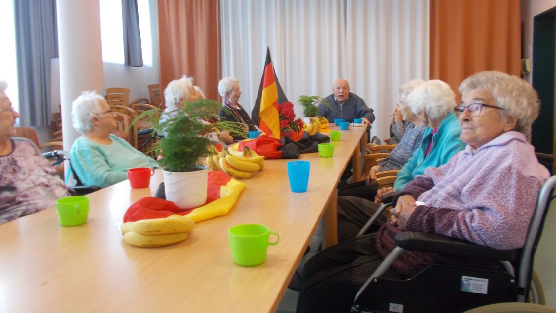 Das Bild zeigt eine Gruppe von Bewohnern im Gespräch zum Tag der deutschen Einheit