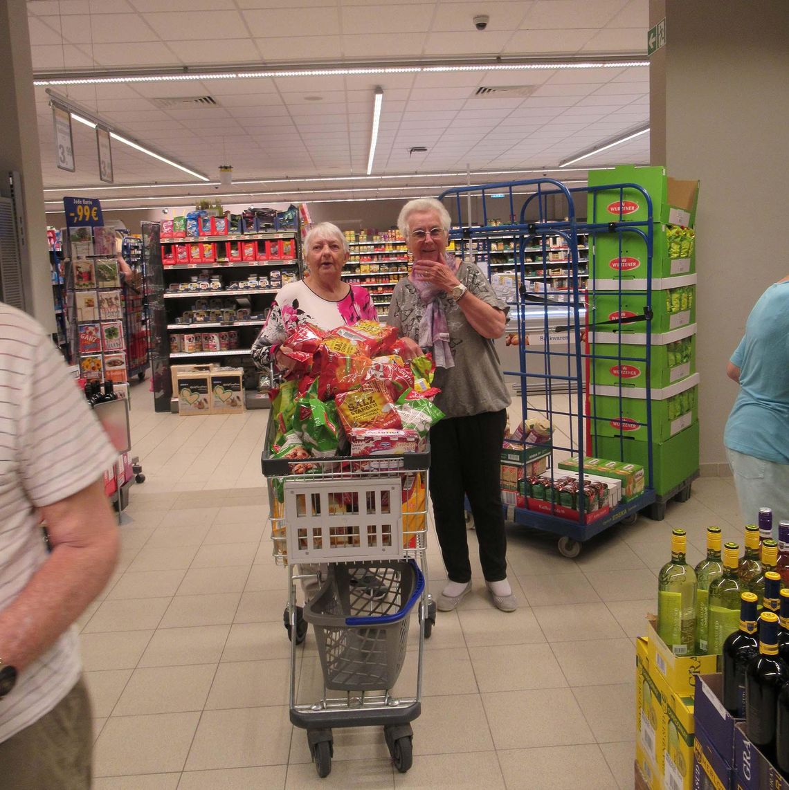 Das Bild zeigt zwei Bewohnerinnen mit einem voll gefüllten Einkaufswagen