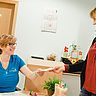 Das Bild zeigt eine Mitarbeiterin an der Anmeldung der Physiotherapie Hudetz