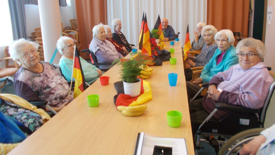 Das Bild zeigt eine Gruppe von Bewohnern im Gespräch zum Tag der deutschen Einheit